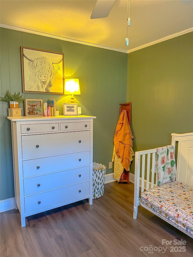 bedroom featuring ornamental molding, baseboards, and wood finished floors