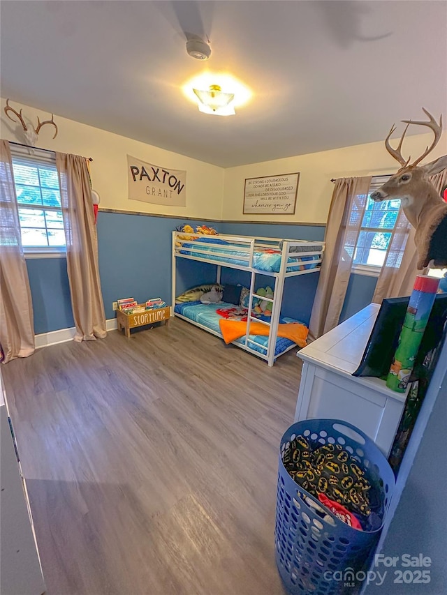 bedroom with wood finished floors and baseboards