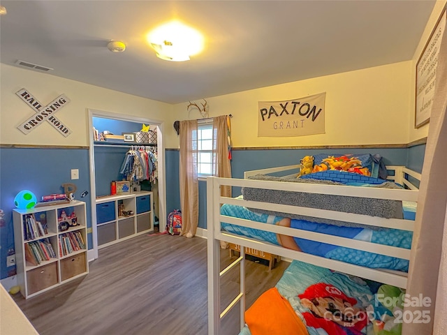 bedroom with a closet, visible vents, and wood finished floors