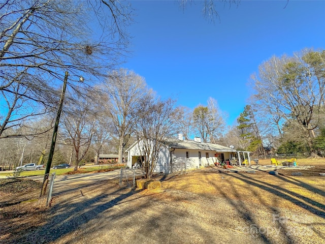 view of home's exterior with driveway and fence