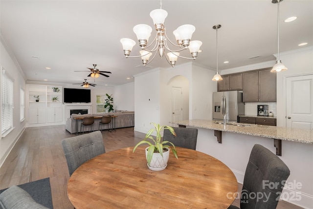 dining space with ornamental molding, sink, and wood-type flooring