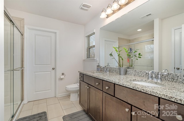 bathroom featuring walk in shower, vanity, toilet, and tile patterned flooring