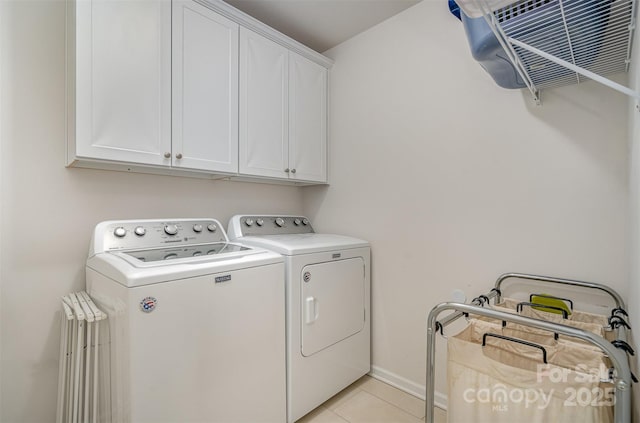 laundry area with cabinets, separate washer and dryer, and light tile patterned floors