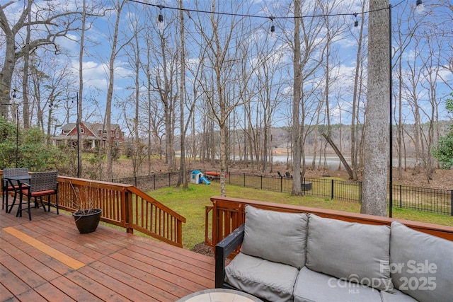 wooden deck featuring a yard, a playground, and a water view