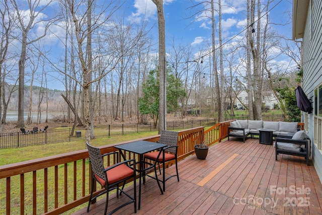 wooden terrace featuring an outdoor hangout area and a lawn