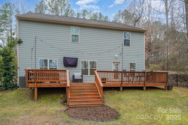 rear view of house with a wooden deck and a yard