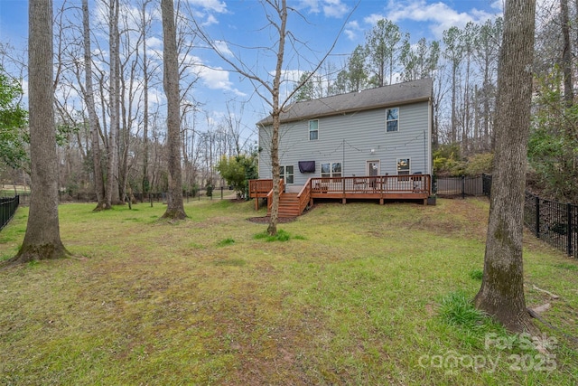 rear view of house with a wooden deck and a lawn