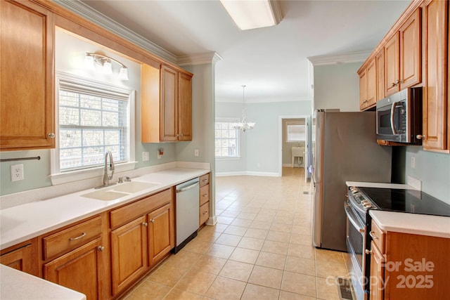 kitchen featuring pendant lighting, appliances with stainless steel finishes, sink, light tile patterned floors, and ornamental molding