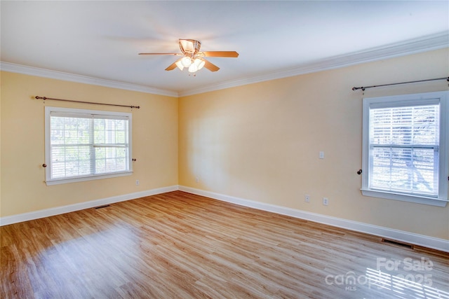 spare room featuring crown molding and light hardwood / wood-style floors