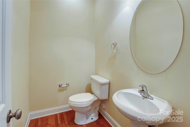 bathroom with hardwood / wood-style flooring, sink, and toilet