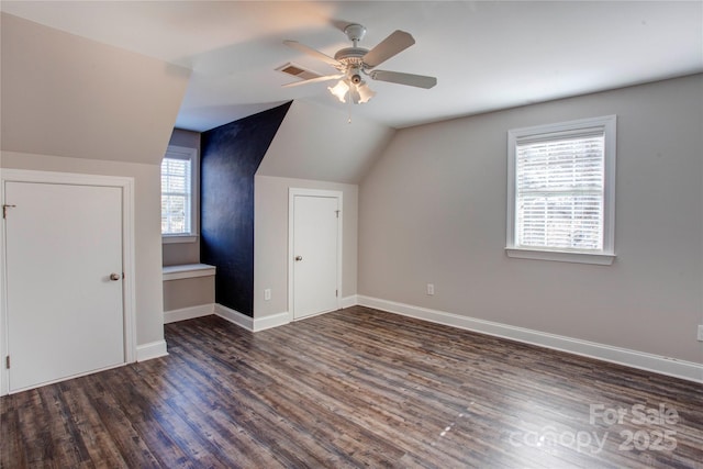 additional living space featuring ceiling fan, a wealth of natural light, dark wood-type flooring, and lofted ceiling