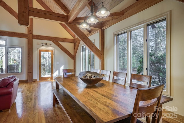 dining area featuring wood ceiling, hardwood / wood-style flooring, and lofted ceiling with beams