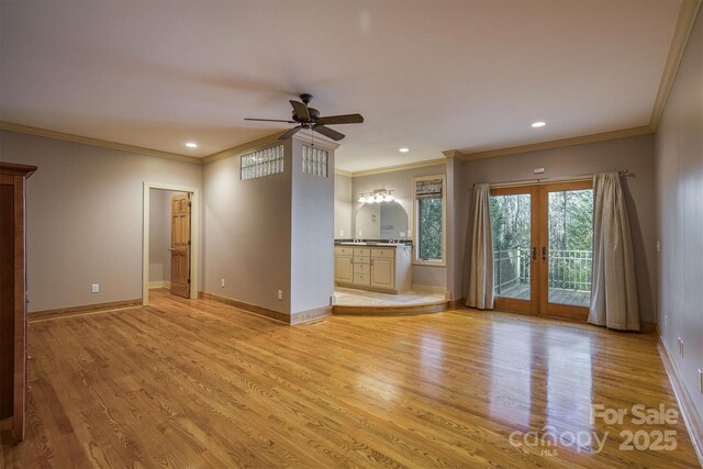 unfurnished living room with crown molding, light wood-type flooring, ceiling fan, and french doors