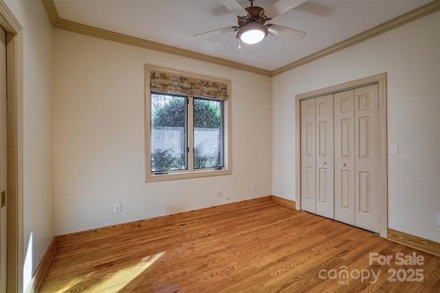 unfurnished bedroom featuring a closet, ceiling fan, crown molding, and light hardwood / wood-style floors