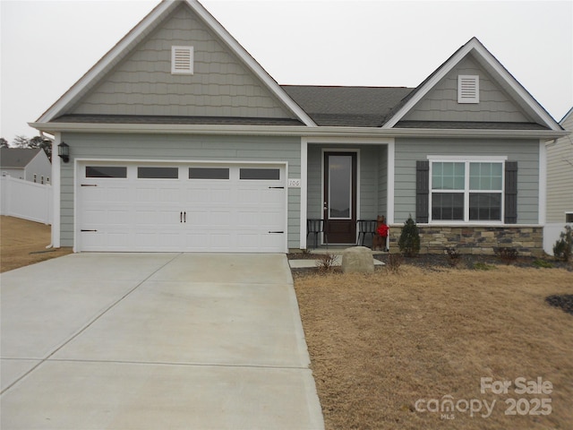 view of front of house with a garage, concrete driveway, and stone siding