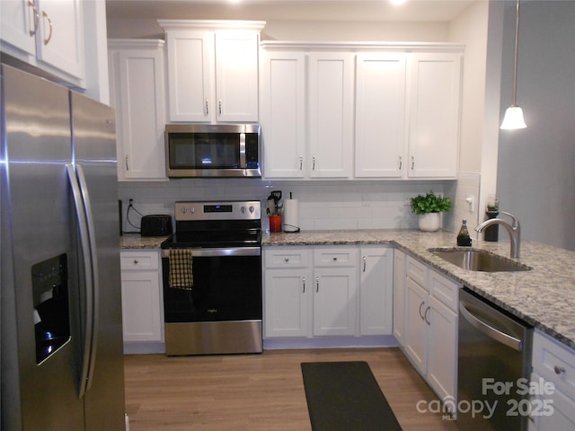 kitchen featuring white cabinetry, appliances with stainless steel finishes, tasteful backsplash, and a sink