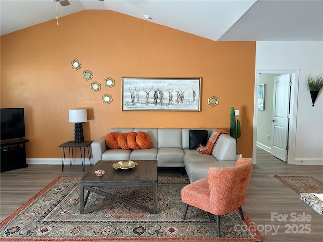 living room with baseboards, vaulted ceiling, and wood finished floors