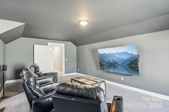 carpeted home theater room with vaulted ceiling