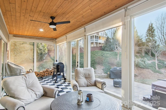 sunroom / solarium featuring ceiling fan, wood ceiling, and a healthy amount of sunlight