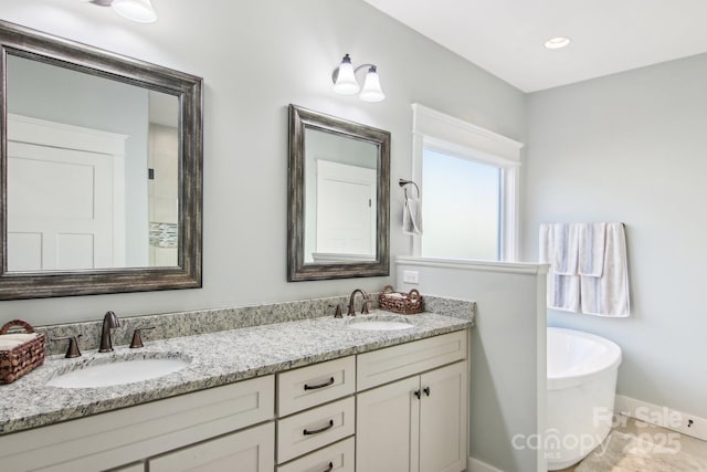 bathroom featuring a washtub and vanity