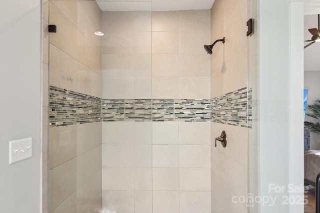 bathroom with ceiling fan and tiled shower