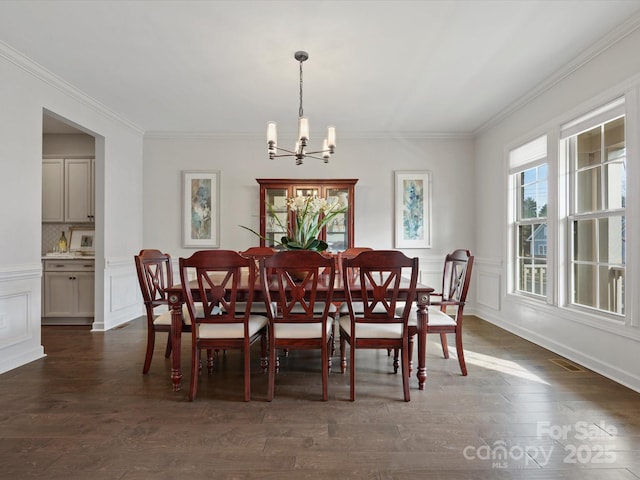 dining space featuring ornamental molding, dark hardwood / wood-style floors, and an inviting chandelier