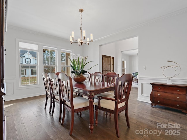 dining space with an inviting chandelier, crown molding, and dark wood-type flooring