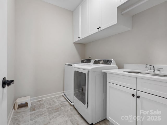 clothes washing area featuring cabinets, separate washer and dryer, and sink