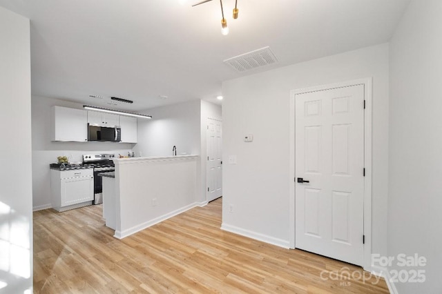 kitchen with light wood-type flooring, white cabinetry, and stainless steel appliances