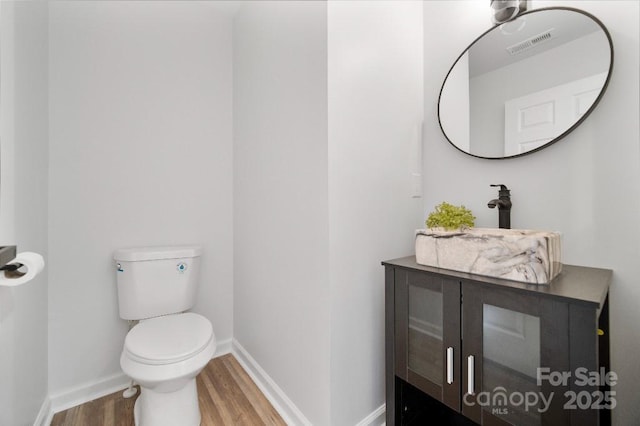 bathroom with sink, toilet, and wood-type flooring