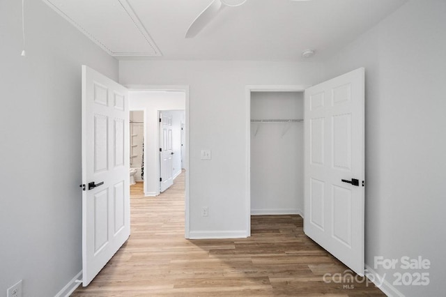 unfurnished bedroom featuring ceiling fan, a closet, and light wood-type flooring