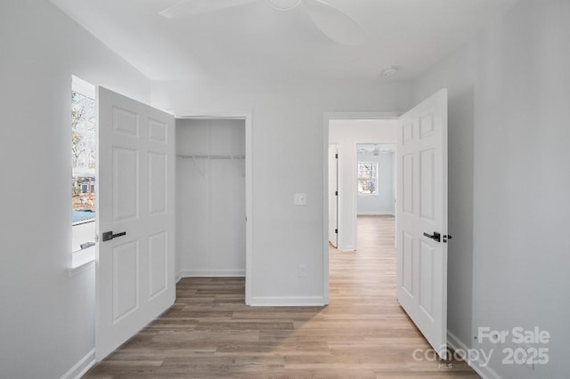 unfurnished bedroom with a closet, ceiling fan, and light wood-type flooring