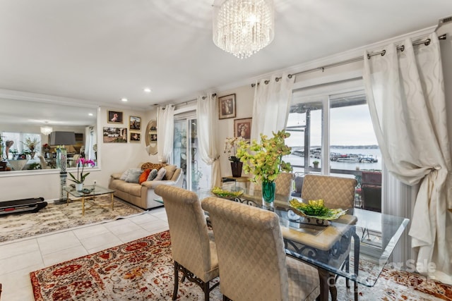 tiled dining area featuring an inviting chandelier, crown molding, and a water view