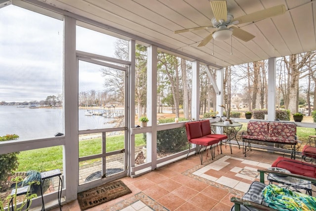 sunroom featuring wooden ceiling, ceiling fan, and a water view