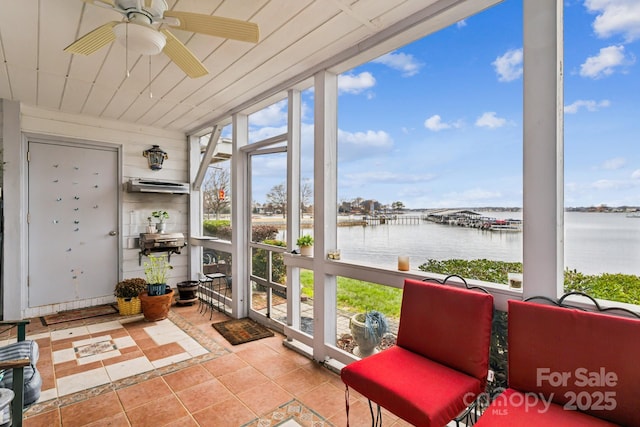 sunroom / solarium featuring ceiling fan and a water view