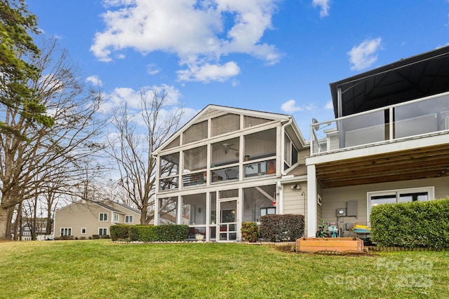 back of property with a sunroom and a lawn