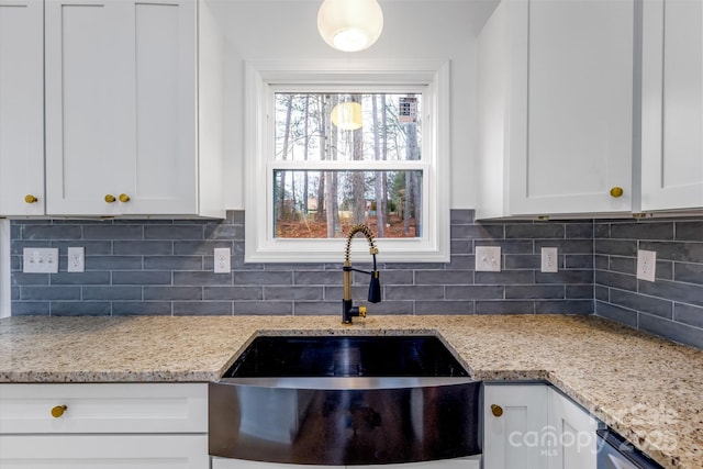 kitchen with white cabinets, backsplash, and sink