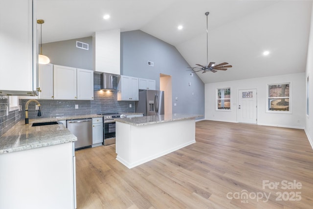 kitchen with a kitchen island, decorative light fixtures, white cabinetry, stainless steel appliances, and sink