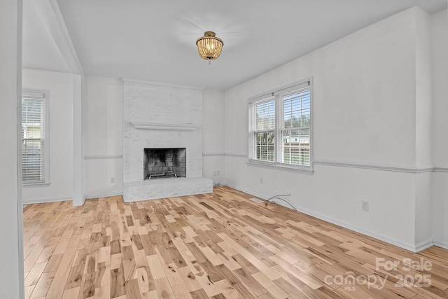 unfurnished living room with a fireplace and light hardwood / wood-style floors