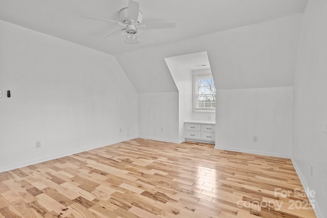 additional living space with light hardwood / wood-style flooring, vaulted ceiling, and ceiling fan