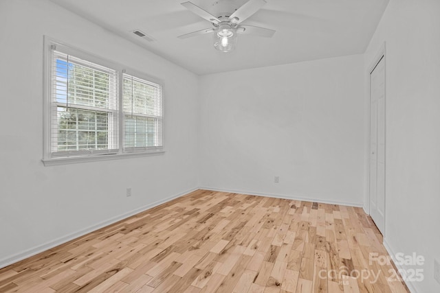 empty room with ceiling fan and light hardwood / wood-style flooring