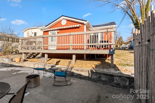 rear view of property featuring a patio area and a deck