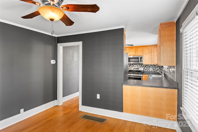 kitchen featuring decorative backsplash, sink, stainless steel appliances, and light hardwood / wood-style floors