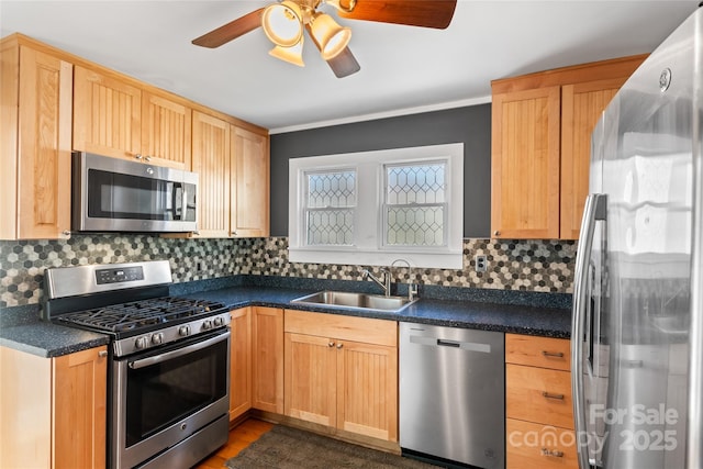 kitchen with appliances with stainless steel finishes, light brown cabinets, decorative backsplash, sink, and ceiling fan