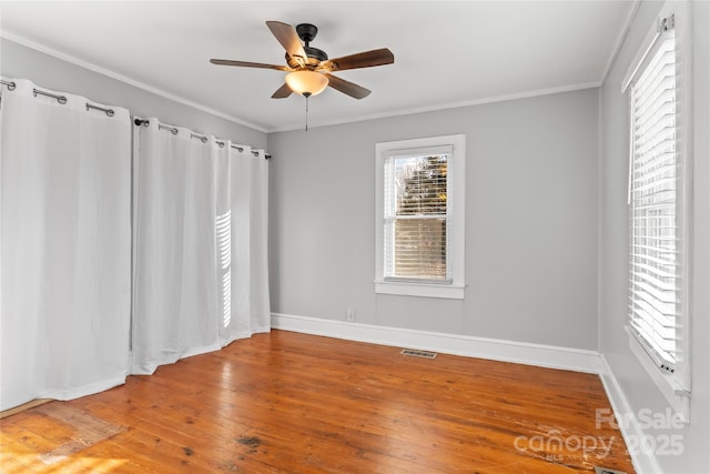 empty room featuring hardwood / wood-style flooring, ceiling fan, and ornamental molding