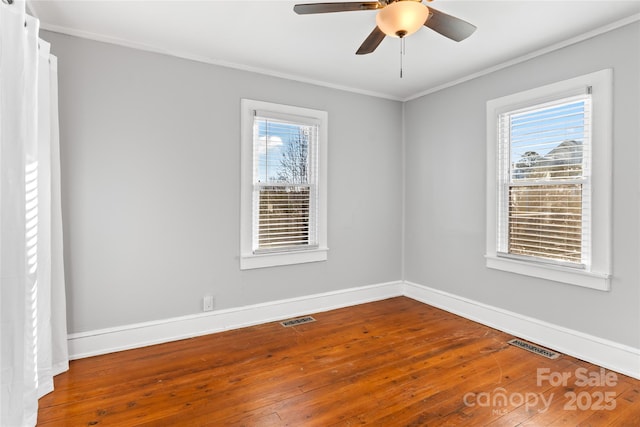 empty room with ceiling fan, ornamental molding, plenty of natural light, and wood-type flooring