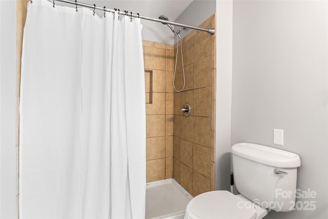 bathroom with a shower with curtain and toilet