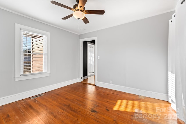 empty room with ceiling fan, wood-type flooring, and crown molding