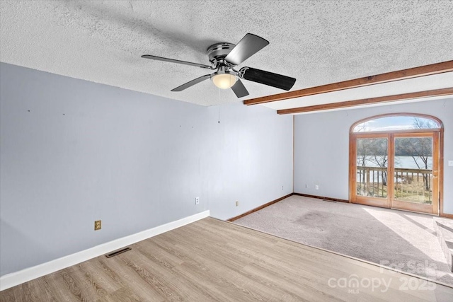 empty room featuring light wood-type flooring and a textured ceiling