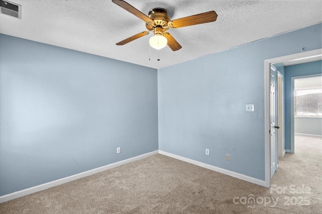 carpeted empty room with ceiling fan and a textured ceiling